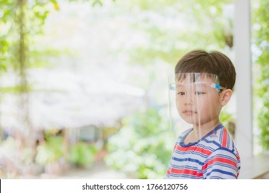 Cute Little Asian Boy Wear Face Mask And Sheild As Protection During The Covid 19 Virus Outbreak. Copy Space.