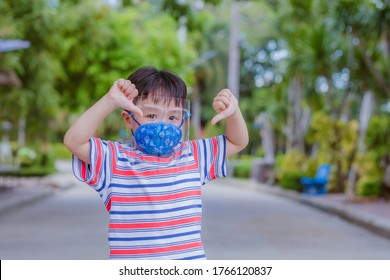 Cute Little Asian Boy Wear Face Mask And Sheild As Protection During The Covid 19 Virus Outbreak. Copy Space.