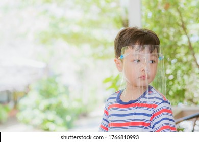 Cute Little Asian Boy Wear Face Mask And Sheild As Protection During The Covid 19 Virus Outbreak. Copy Space.