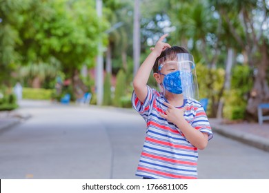 Cute Little Asian Boy Wear Face Mask And Sheild As Protection During The Covid 19 Virus Outbreak. Copy Space.