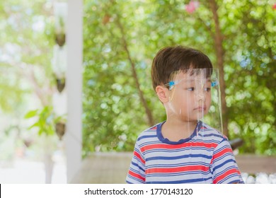 Cute Little Asian Boy Wear Face Mask And Sheild As Protection During The Covid 19 Virus Outbreak. Copy Space.