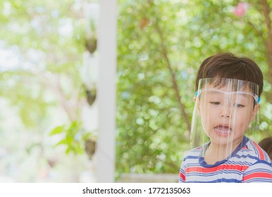 Cute Little Asian Boy Wear Face Mask And Sheild As Protection During The Covid 19 Virus Outbreak. Copy Space.