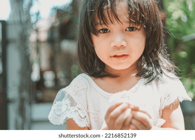 Cute Little Asian Girl Holding A White Bouquet. Child Planting Spring Flowers. 