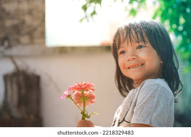 Cute Little Asian Girl Holding A Pink Bouquet. Child Planting Spring Flowers. 