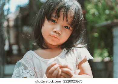 Cute Little Asian Girl Holding A White Bouquet. Child Planting Spring Flowers. 