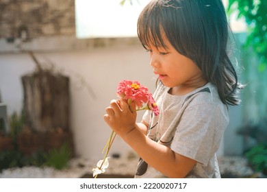 Cute Little Asian Girl Holding A Pink Bouquet. Child Planting Spring Flowers. 