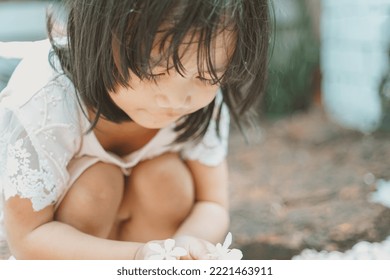 Cute Little Asian Girl Holding A White Bouquet. Child Planting Spring Flowers. 