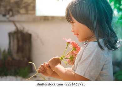 Cute Little Asian Girl Holding A Pink Bouquet. Child Planting Spring Flowers. 