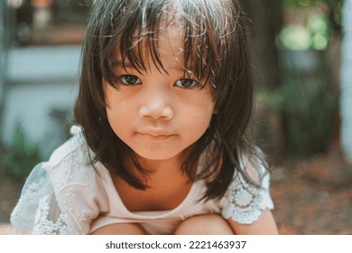 Cute Little Asian Girl Holding A White Bouquet. Child Planting Spring Flowers. 