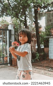 Cute Little Asian Girl Holding A Pink Bouquet. Child Planting Spring Flowers. 