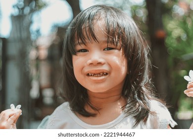 Cute Little Asian Girl Holding A White Bouquet. Child Planting Spring Flowers. 