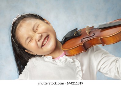 Cute Little Asian Girl Playing The Violin Very Enjoying .