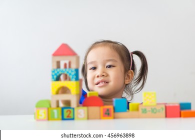 Cute Little Asian Girl Playing Wooden Building Blocks.