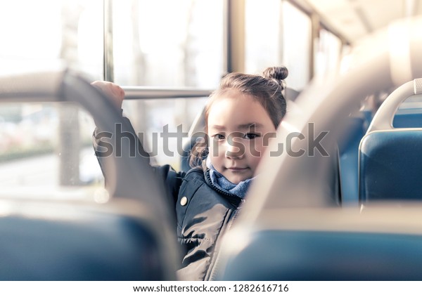 The cute little\
Asian girl smiled on the\
bus.