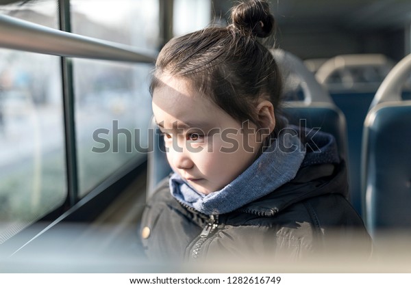 The cute little
Asian girl smiled on the
bus.