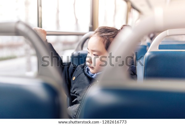 The cute little\
Asian girl smiled on the\
bus.