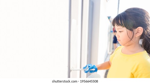 Cute Little Asian Kid Girl Painting On Wall Cement Fence Outdoor.Volunteer Kid Project Painting Wall In Local School.renovate.kid Holding Brush.renew House.Paint Color.Home, Community Service.charity.