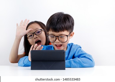 Cute little Asian sibling using video chat on a tablet at home - Powered by Shutterstock