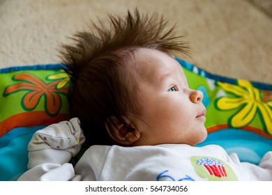 Cute Little Baby Boy With Brown Hairy Iroquois Is Lying And Looking Somewhere