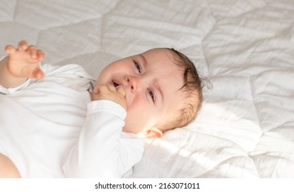 Cute Little Baby Boy Is Crying. Toddler On Bed, White Blanket,sunny Rays, Morning Situation.motherhood. Teething Period,bloating Belly Pain, Want To Sleep,eat, Hungry Child