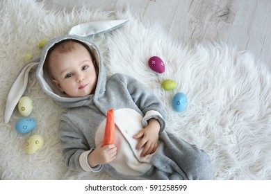 Cute Little Baby In Bunny Costume Lying On Furry Rug