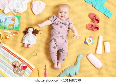 Cute Little Baby With Clothing And Accessories On Color Blanket, Top View