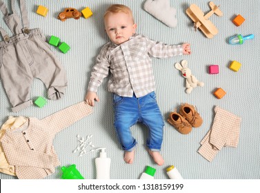 Cute Little Baby With Clothing And Accessories On Color Blanket, Top View