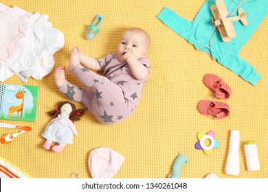 Cute Little Baby With Clothing And Accessories On Color Blanket, Top View