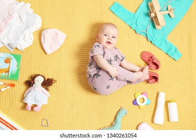 Cute Little Baby With Clothing And Accessories On Color Blanket, Top View