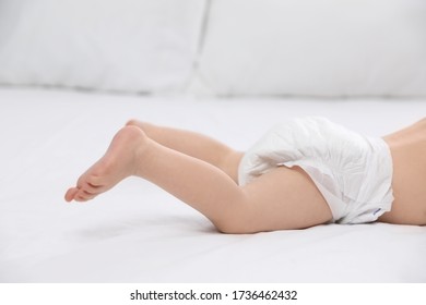 Cute Little Baby In Diaper On Bed, Closeup