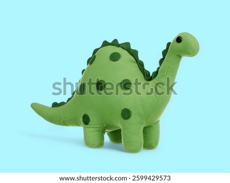 Cute little baby dinosaur soft toy on the blue background