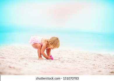 Cute Little Baby Girl In Tutu Swimwear Play With Sand At Exotic Beach Background. Toddler Ballerina.