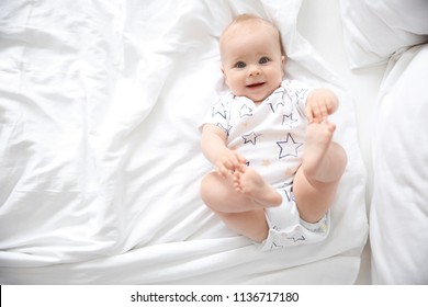Cute little baby lying on bed, top view