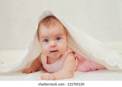Cute little baby lying under white blanket - Shutterstock ID 115705150