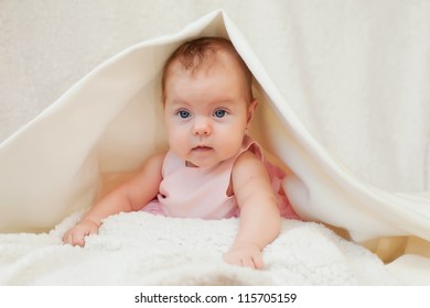 Cute little baby lying under white blanket - Shutterstock ID 115705159
