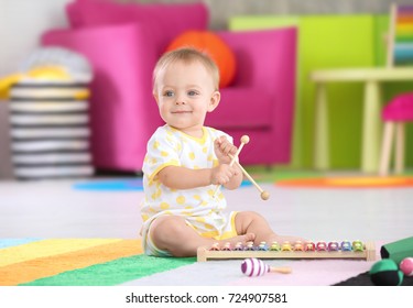 Cute Little Baby Playing With Musical Instrument At Home