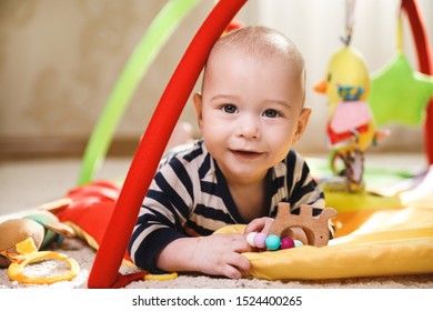 Cute little baby is playing on the activity mat 