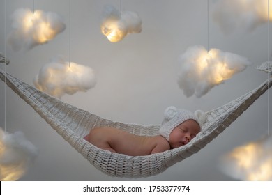 Cute Little Baby Sleeping In The Hammock With A Lot Clouds Made Of Cotton Wool