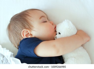 baby hugging teddy bear