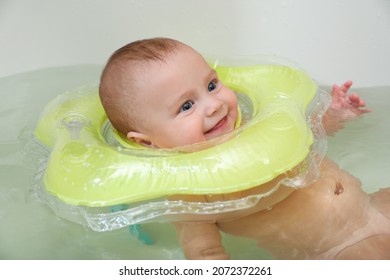 Cute Little Baby Swimming With Inflatable Ring In Bath