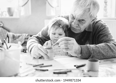 Cute Little Baby Toddler Girl And Handsome Senior Grandfather Painting With Pencils At Home. Grandchild And Man Having Fun Together. Family And Generation In Love. Old Black And White Image