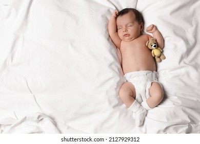 Cute Little Baby With Toy Bear Sleeping On Soft Bed, Top View. Space For Text