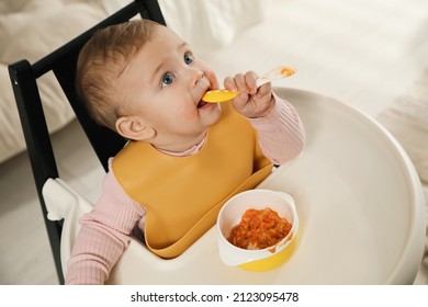 Cute Little Baby Wearing Bib While Eating At Home