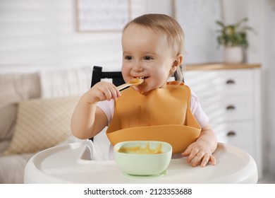 Cute Little Baby Wearing Bib While Eating At Home