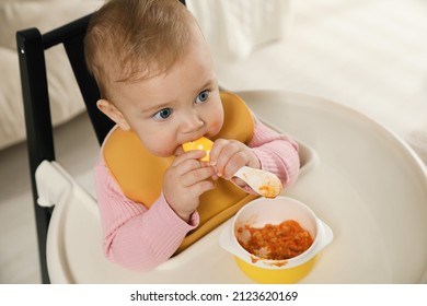 Cute Little Baby Wearing Bib While Eating At Home