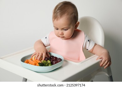 Cute Little Baby Wearing Bib While Eating On White Background