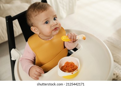 Cute Little Baby Wearing Bib While Eating At Home