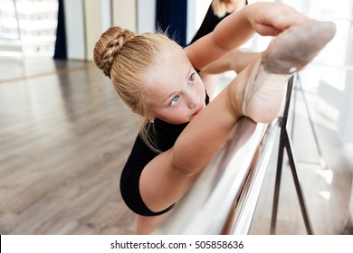 Cute Little Ballet Dancer Training And Stretching Legs In Dance Class