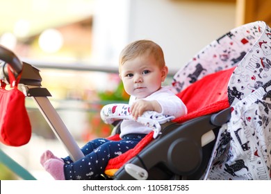 Cute Little Beautiful Baby Girl Sitting In The Pram Or Stroller On Cold