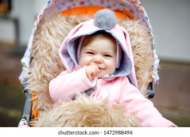 Cute Little Beautiful Baby Girl Sitting In The Pram Or Stroller On Cold